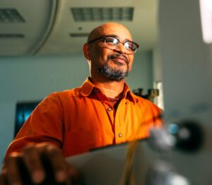 Man with hand on a mouse looking at computer